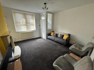 a living room with a couch and chairs in it at Cumberland House-2 Bed House in Workington