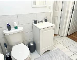 a white bathroom with a toilet and a sink at Queen Suite with Wifi with Hot Tub Room 6 in Atlanta