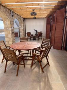 un tavolo e sedie in legno in una stanza di Beautiful Home - Luxury Villa where you can party ad Armou