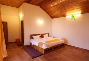 una camera con letto e soffitto in legno di Mayflower Holiday Villa a Meppādi