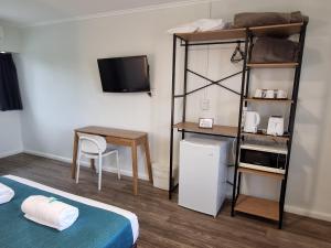 a bedroom with a bunk bed and a table and a desk at Bargara Beach Hotel in Bargara