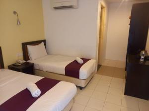 a hotel room with two beds and a window at Syajie Koptown Hotel in Segamat