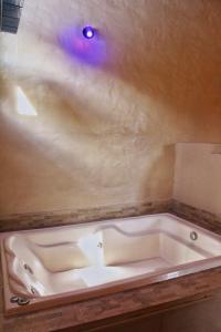 a bath tub with a purple light on the ceiling at Villa dos Pireneus in Pirenópolis +26 photos