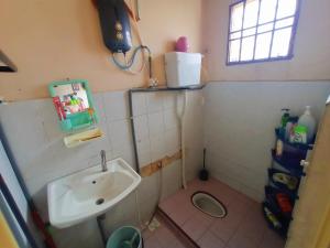 La petite salle de bains est pourvue d'un lavabo et de toilettes. dans l'établissement Homestay Melewar, à Parit Raja
