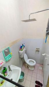 a bathroom with a toilet and a sink at Homestay Melewar in Parit Raja