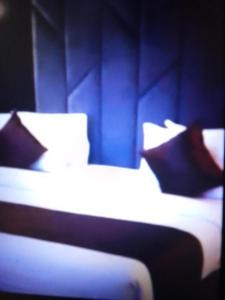 2 łóżka z poduszkami w niebieskim pokoju w obiekcie Villa toscana luxe hotel port Harcourt w mieście Port Harcourt