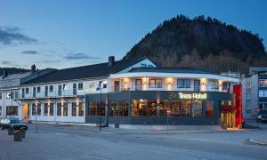 ein Gebäude auf einer Straße mit einem Berg im Hintergrund in der Unterkunft Tino's Hotel in Namsos