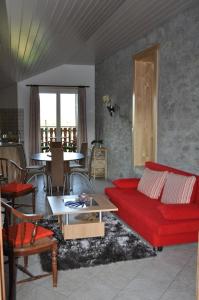 a living room with a red couch and a table at Studio de Vacances Philipona in Granges