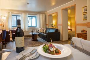 eine Flasche Wein und ein Teller mit Essen auf dem Tisch in der Unterkunft Tino's Hotel in Namsos