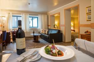 una botella de vino y un plato de comida en una mesa en Tino's Hotel, en Namsos
