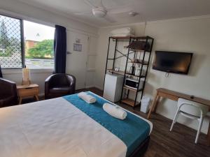 a bedroom with a large bed with two pillows on it at Bargara Beach Hotel in Bargara