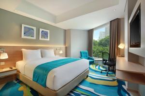 a hotel room with a bed and a window at Holiday Inn Express Jakarta Wahid Hasyim, an IHG Hotel in Jakarta