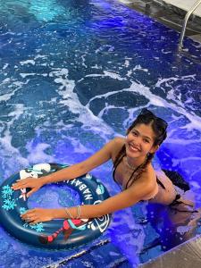 Ein junges Mädchen im Schwimmbad mit Floß. in der Unterkunft Celia Boutique Hotel in Phong Nha