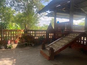 una valla de madera con un banco en un patio en Homestay tay, en Xã Trảng Bôm