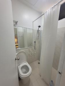 een witte badkamer met een toilet en een douche bij Ontrack Travel in Male City