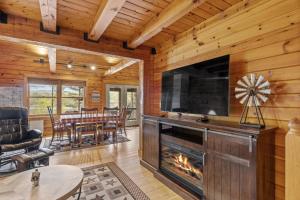 ein Wohnzimmer mit einem Kamin und einem Flachbild-TV in der Unterkunft Private Lakefront! - Luxury Log House! in Sanbornton