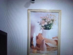 a picture of a vase with flowers in a mirror at Exclusive mansion hotel and suites Lagos in Ilado