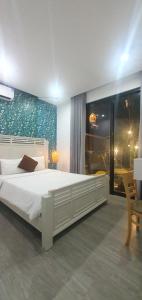 a bedroom with a large white bed and a window at Villa 68 4BR FREE PICK-UP AIRPORT & BILLIARDS CLOSE TO MY KHE BEACH in Da Nang