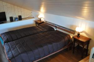 a bed in a room with two night stands and two lamps at Studio de Vacances Philipona in Granges