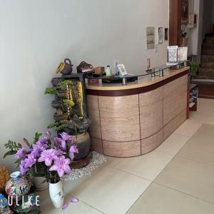 um lobby com um balcão com flores roxas no chão em Hanoi Rose Flower Hotel & Spa em Hanói