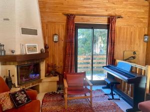 a living room with a piano and a fireplace at Chalet pour 10 pers aux Angles avec poêle à granules, parking et navette - FR-1-758-26 in Les Angles