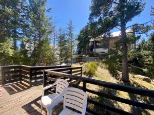 two white chairs sitting on a wooden deck at Chalet pour 10 pers aux Angles avec poêle à granules, parking et navette - FR-1-758-26 in Les Angles