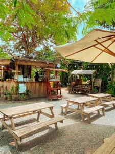 a group of picnic tables and an umbrella at Binifarm Tropical Retreat in Cu Chi