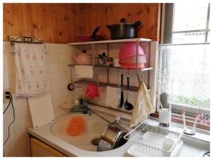 eine Küche mit einer Spüle und einer Arbeitsplatte in der Unterkunft Folks House in Eniwa