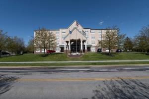 duży biały budynek z zegarem z przodu w obiekcie Country Inn & Suites by Radisson, Harrisburg - Hershey West, PA w mieście Harrisburg