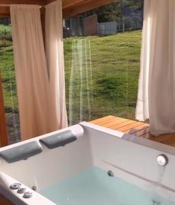 a bath tub in front of a window at Pousada Morada das Araucarias in Pôrto Vitória