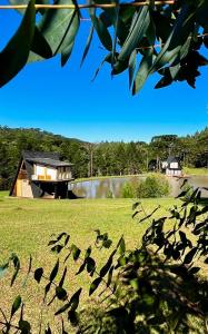una casa sentada en la cima de un exuberante campo verde en Pousada Morada das Araucarias en Pôrto Vitória