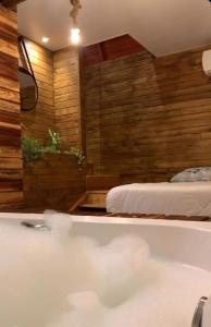 a bath tub in a room with a bed at Pousada Morada das Araucarias in Pôrto Vitória