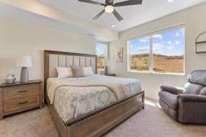 een slaapkamer met een bed, een stoel en een raam bij View to Renew condo in St. George