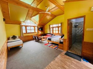 a bedroom with yellow walls and a bed and a table at The Four Season Hotel & Resort, Manali in Manāli