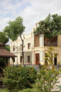 a large white building with trees in front of it at Ko'k Saroy Plaza Hotel in Samarkand