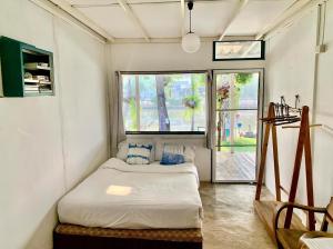 mały pokój z łóżkiem i oknem w obiekcie Ban Narai River Guesthouse w mieście Chiang Mai