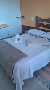 duas camas com lençóis brancos e toalhas em Pousada Alforria em Lavras Novas