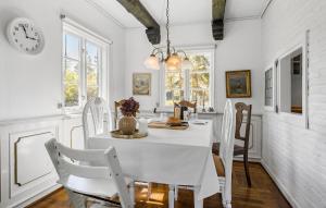uma sala de jantar branca com uma mesa e cadeiras brancas em 3 Bedroom Amazing Home In Vig em Vig