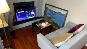 Télévision ou salle de divertissement dans l'établissement Lily room near golf and banff costco newly renovated queen size bed Single bathroom sofa TV