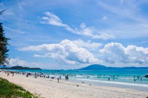 a group of people on a beach in the ocean at Khách sạn Xuân Dương in Cửa Lô