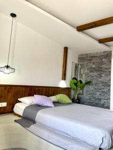 a bedroom with a large bed with a brick wall at Kostas Studios in Faliraki