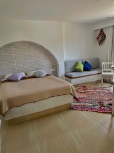 a bedroom with a large bed and a couch at Kostas Studios in Faliraki