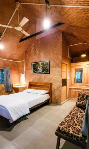 een slaapkamer met een bed en een bank in een kamer bij Monsoon Retreats Ecostay- Treehouse in Thekkady