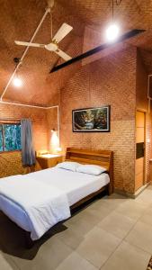 een slaapkamer met een groot bed en een plafondventilator bij Monsoon Retreats Ecostay- Treehouse in Thekkady