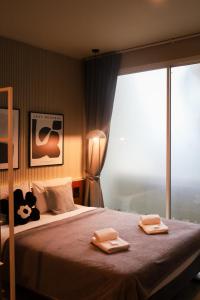 - une chambre avec un lit et 2 serviettes dans l'établissement LAZYDAY IN NIMMAN, à Chiang Mai
