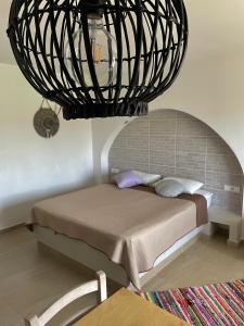 a bedroom with a bed under a chandelier at Kostas Studios in Faliraki