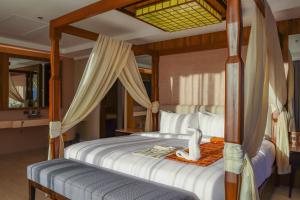 1 dormitorio con cama con dosel y colcha blanca en Mandarin Bay Resort and Spa, en Boracay