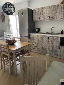 a kitchen with a wooden table and chairs and a kitchen with a sink at Kostas Studios in Faliraki