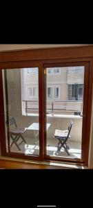una ventana con vistas a un patio con una mesa y un banco en Özçelik apartmanı, en Alanya