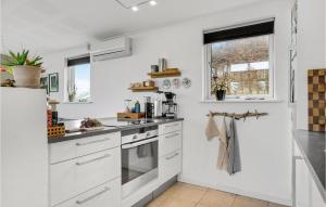 a white kitchen with white cabinets and a window at Awesome Home In Børkop in Børkop